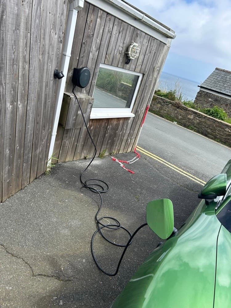 EV charger installed at a Cornwall coastal property, sea visible in the background